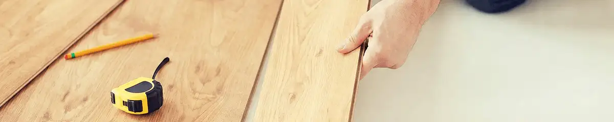 A professional installing wood flooring in Houston, TX