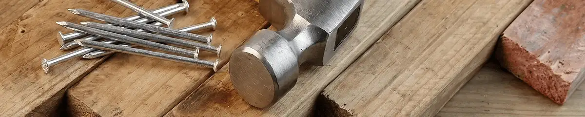 Hammer and nails on hardwood flooring boards in Houston, TX